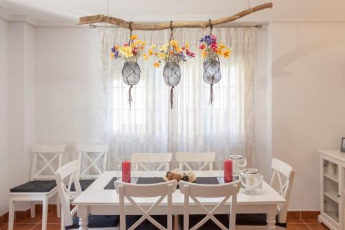 苏安塞斯Chalet junto a playa de Suances的白色的用餐室配有白色的桌椅