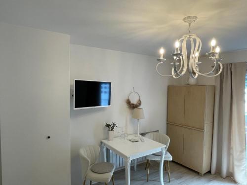 科赫姆Gästehaus Paulina的一间设有白色桌子和吊灯的用餐室