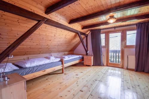班斯卡比斯特里察River Valley View House的木制客房内的一间卧室配有两张床