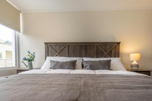 维纳德马Praia 58 Reñaca的一间卧室配有一张大床和木制床头板