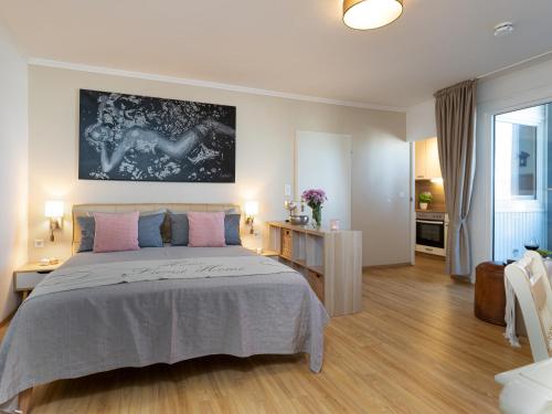 韦斯特兰Ferienwohnung im Herzen vom Sylt的一间卧室配有一张大床,配有粉色和蓝色的枕头