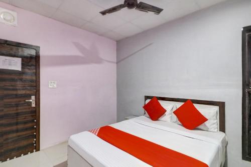 法里达巴德OYO Siya Residency的一间卧室配有红色和白色枕头的床