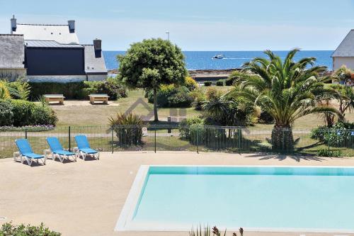 吉尔维内克LocaLise au Guilvinec - A15 - Vue sur la mer la piscine et le jardin - Tout à pied, plages, port, centre, commerces, marché - Wifi inclus - Animaux bienvenus - Linge de lit inclus的一个带两把蓝色椅子的游泳池以及大海