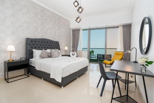 迪拜White Sage - Incredible Full Sea and Dubai Eye View in Marina的一间卧室配有一张床、一张桌子和一张书桌