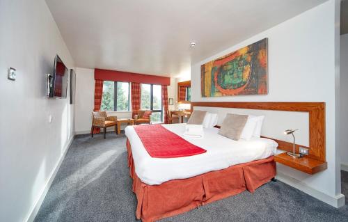 赫尔拉萨特酒店的一间卧室配有一张带红色毯子的大床