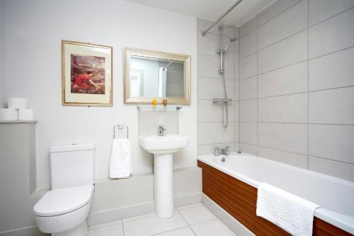 赫尔拉萨特酒店的白色的浴室设有水槽、浴缸和卫生间。