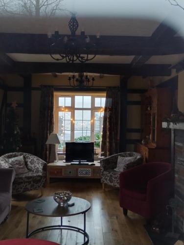 恩尼斯基林Rossclare Lodge的客厅配有沙发和桌子
