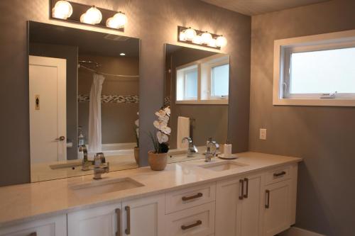 维多利亚Galloping Goose B&B in Beautiful Victoria的一间带两个盥洗盆和大镜子的浴室