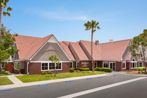 帕姆代尔Residence Inn by Marriott Palmdale Lancaster的一座拥有红色屋顶和棕榈树的房子
