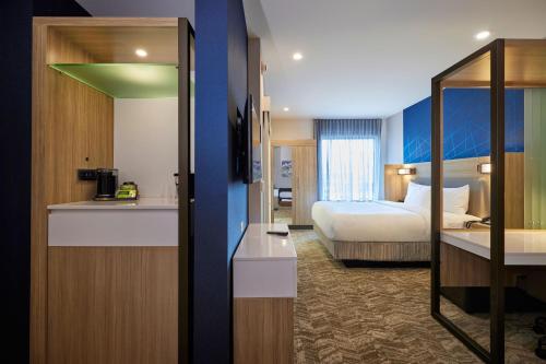 梅德福SpringHill Suites by Marriott Medford Airport的酒店客房设有一间带一张床的卧室和一间厨房