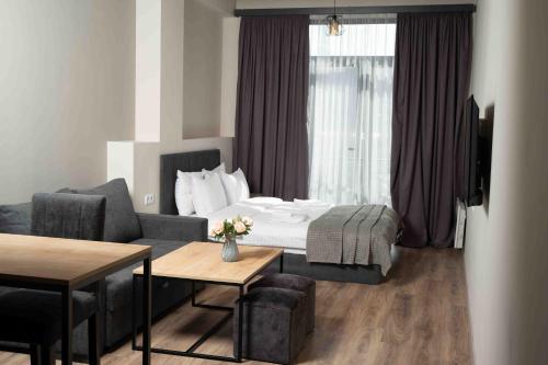 萨克德佐尔镇Forest Apartments Hotel的酒店客房配有床、沙发和桌子。