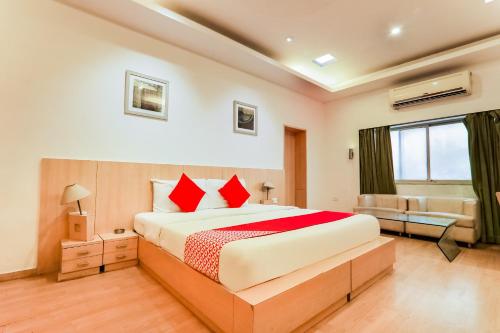 巴雷利Resort Sita Kiran的一间卧室配有一张带红色枕头的大床