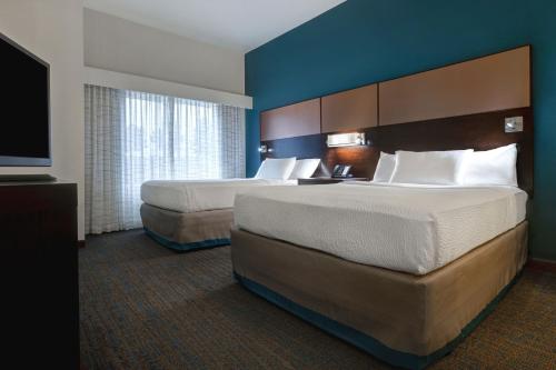 普尔曼铂尔曼原住客栈酒店的酒店客房设有两张床和一台平面电视。