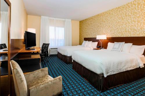 佩科斯Fairfield Inn & Suites by Marriott Pecos的酒店客房设有两张床和电视。