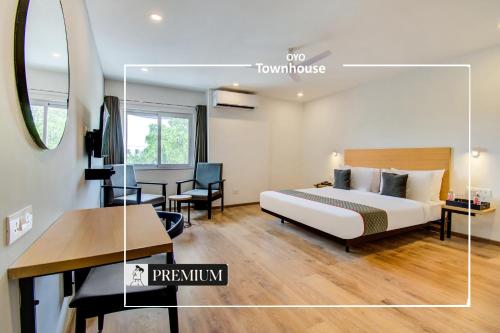 艾哈迈达巴德Townhouse 165 Netaji Road的酒店客房配有一张床铺、一张桌子和一张书桌。