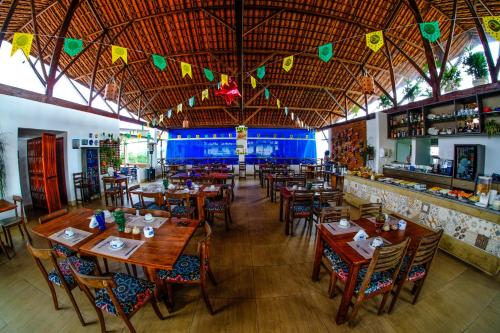 阿雷亚Hotel Fazenda Triunfo的一间带木桌椅的餐厅和一间酒吧