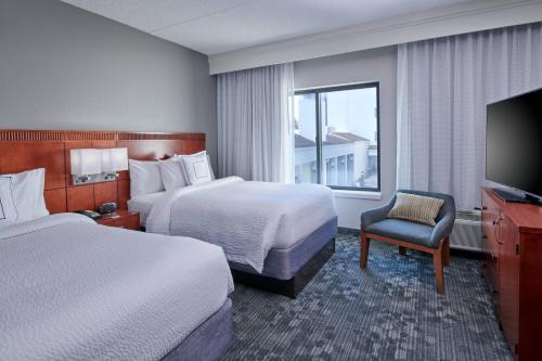 印第安纳波利斯Courtyard by Marriott Indianapolis Castleton的酒店客房设有两张床和电视。