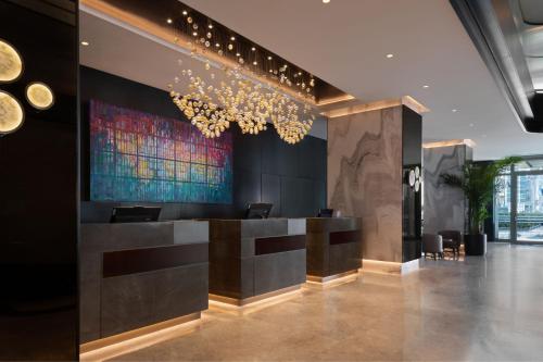 伊兹密尔Izmir Marriott Hotel的大堂设有酒吧,墙上挂有绘画作品