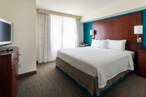 奥欣赛德圣地亚哥海滨原住客栈的一间酒店客房,配有一张大床和一台平面电视