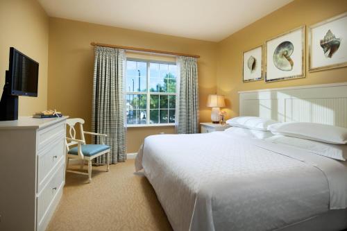 默特尔比奇Sheraton Broadway Resort Villas的一间卧室设有一张大床和一个窗户。
