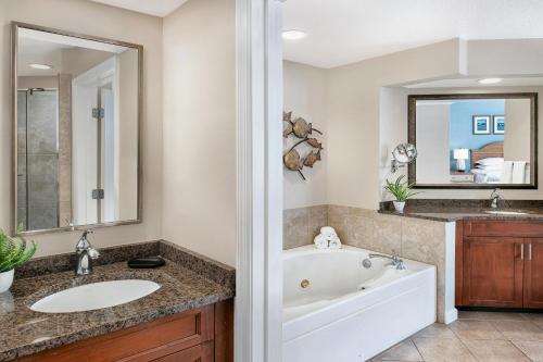 默特尔比奇Sheraton Broadway Resort Villas的带浴缸、水槽和镜子的浴室