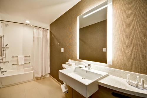 布鲁艾施SpringHill Suites by Marriott Cincinnati Blue Ash的浴室配有盥洗盆、镜子和浴缸