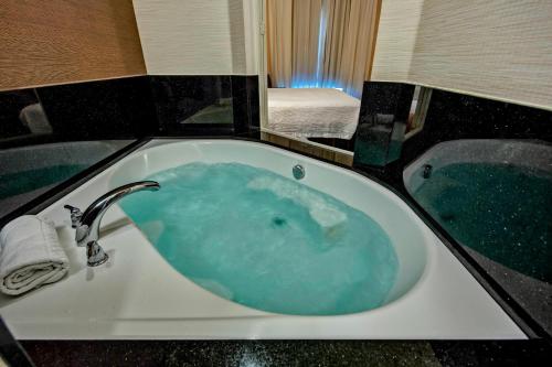 韦瑟福德韦瑟福德万豪费尔菲尔德客栈及套房酒店的浴室设有装满蓝色水的浴缸。