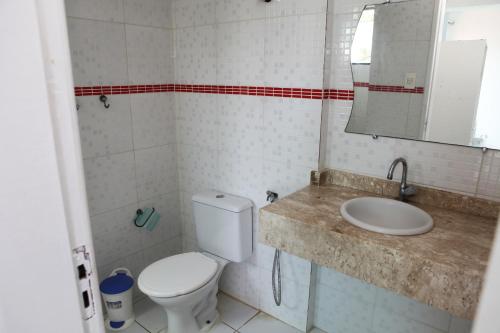 孔迪Hotel Pousada Oasis的一间带卫生间、水槽和镜子的浴室