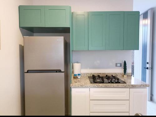 马萨特兰Excelente Depa en Sabalo Country的厨房配有绿色橱柜和冰箱。