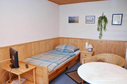黑明根GARNI的一间卧室配有一张床和一张桌子及电视