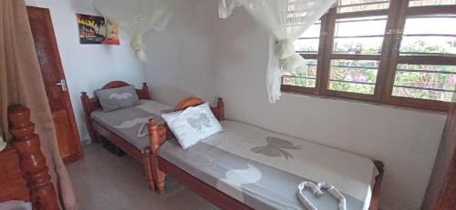 江比阿Villa Sunshine House ZANZIBAR的小房间设有两张床和窗户