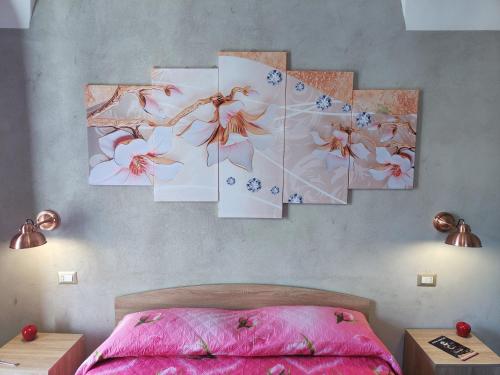 卡塔尼亚Pantaleone Holiday House的卧室的墙上装饰有四幅画作