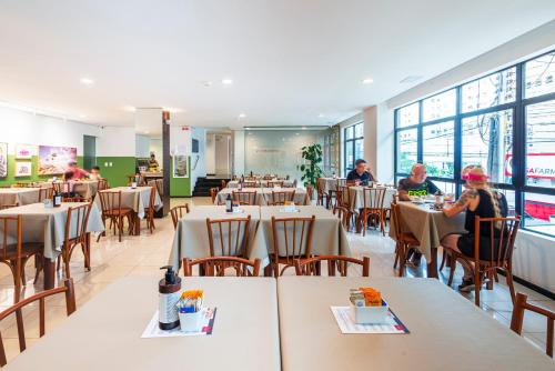 巴拉奈里奥-坎布里乌梅洛酒店的一间设有桌子的餐厅,有坐在桌子上的人