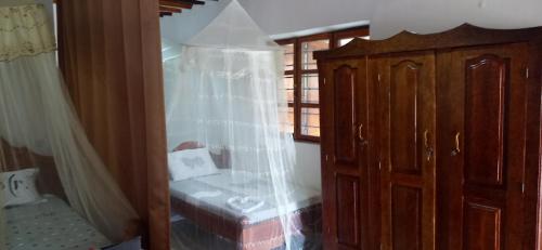 江比阿Villa Sunshine House ZANZIBAR的一间卧室配有一张床和一个带蚊帐的梳妆台。
