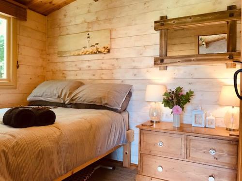 Weston LongvilleTranquil Log Cabin - Beautiful Rural Sunset Views的一间卧室设有一张床和木墙