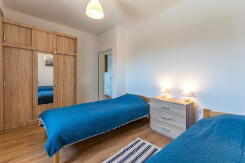 巴比诺波尔杰Mljet, old stone apartment with pool in nature的一间卧室设有两张床和一张带蓝色床单的梳妆台。