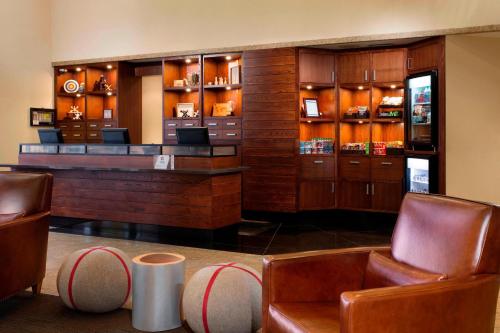 加蒂诺Four Points by Sheraton Hotel & Conference Centre Gatineau-Ottawa的餐厅内的酒吧配有皮椅和桌子