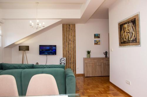 克鲁舍瓦茨Apartman MIA Centar的客厅配有绿色沙发和电视