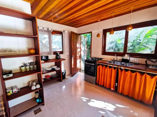 阿布拉奥Casa Iluminalia的厨房配有水槽和带橙色窗帘的台面
