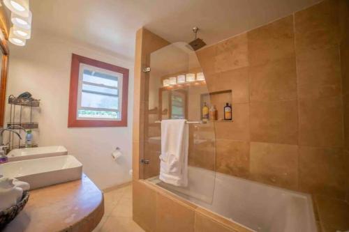 哈纳Hana Homestead的带淋浴、盥洗盆和浴缸的浴室