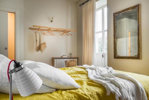 圣马丹德雷LE SECRET的一间卧室配有一张带黄色床单和镜子的床