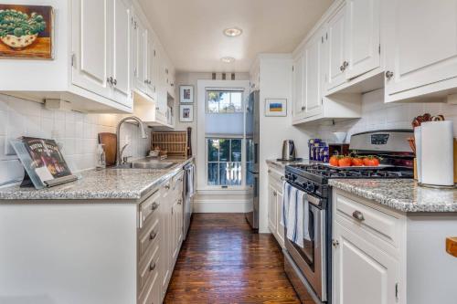 SwampscottSeaCity View的厨房配有白色橱柜和大理石台面