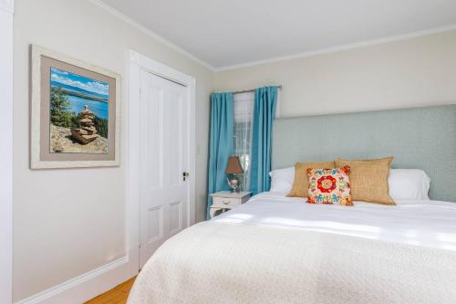 SwampscottSeaCity View的卧室配有白色的床和蓝色窗帘