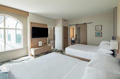 哥伦布Sheraton Suites Columbus Worthington的酒店客房设有两张床和一台平面电视。