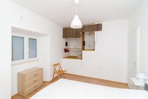 巴比诺波尔杰Mljet, old stone apartment with pool in nature的卧室拥有白色的墙壁,配有一张床和椅子