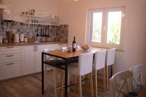 萨格里什Casa Boa Onda的厨房配有带白色椅子的桌子和窗户。