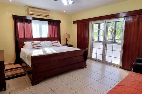 特拉Huellas en la arena Casa De Playa的一间卧室设有一张大床和一个滑动玻璃门