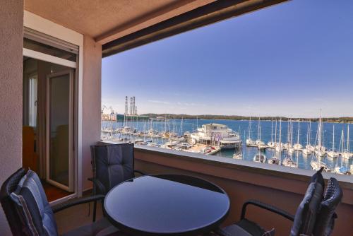 普拉Studio Apartment Harbour Pula的阳台配有桌椅,享有码头的景致。