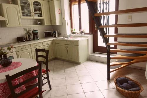 TrassemFerienhaus La Meu的厨房设有绿色橱柜,厨房设有楼梯