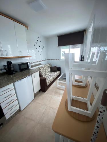 布埃乌Bueu的厨房以及带白色橱柜和沙发的客厅。